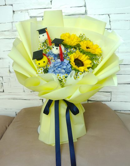 A085 ช่อดอกไม้แสดงความยินดี จัดด้วยดอกทานตะวัน ไฮเดรนเยียสีฟ้า และดอกปิงปองบัณฑิต 3 ดอก ห่อด้วยกระดาษสีเหลืองอ่อน