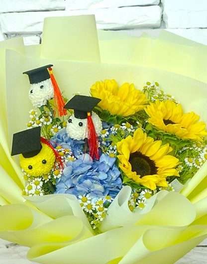 A085 ช่อดอกไม้แสดงความยินดี จัดด้วยดอกทานตะวัน ไฮเดรนเยียสีฟ้า และดอกปิงปองบัณฑิต 3 ดอก ห่อด้วยกระดาษสีเหลืองอ่อน